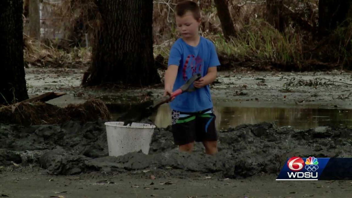 <i>WDSU</i><br/>A boy shovels the mud to get to his home in lower Lafitte.