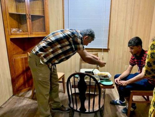 Adel Khaffaji, of the Islamic Center of Central Missouri, helps newly arrived Afghan refugee Fazal with a donated warm meal on Sunday, Sept. 26, 2021, in Columbia.