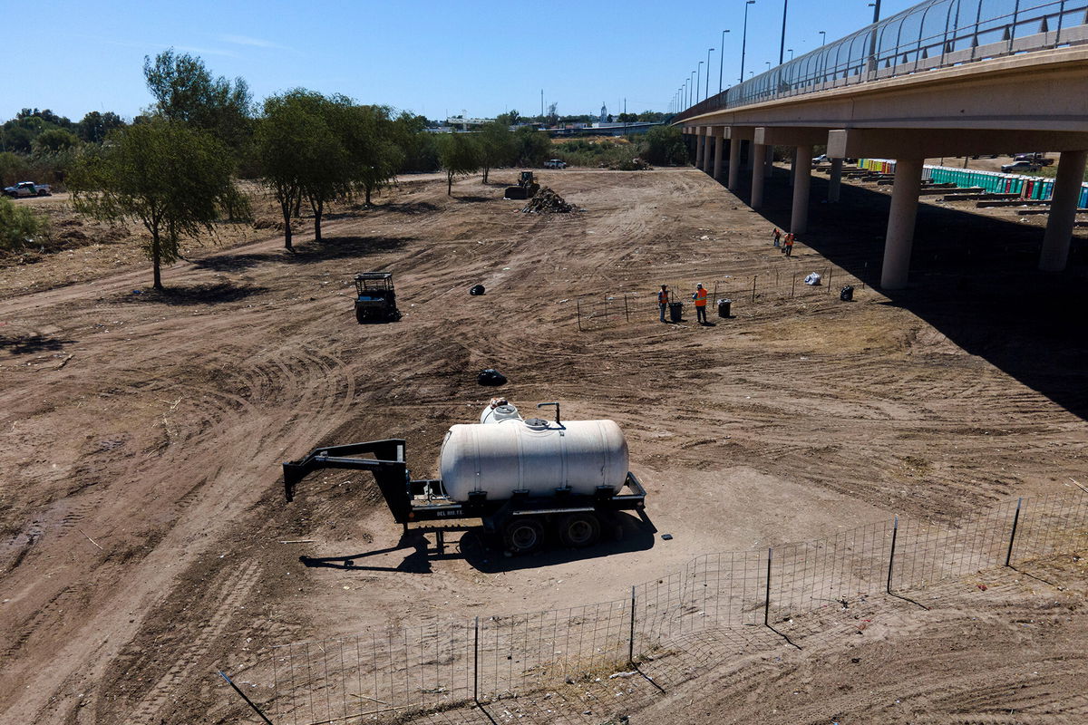 <i>Julio Cortez/AP</i><br/>Crews clear an area used by migrants