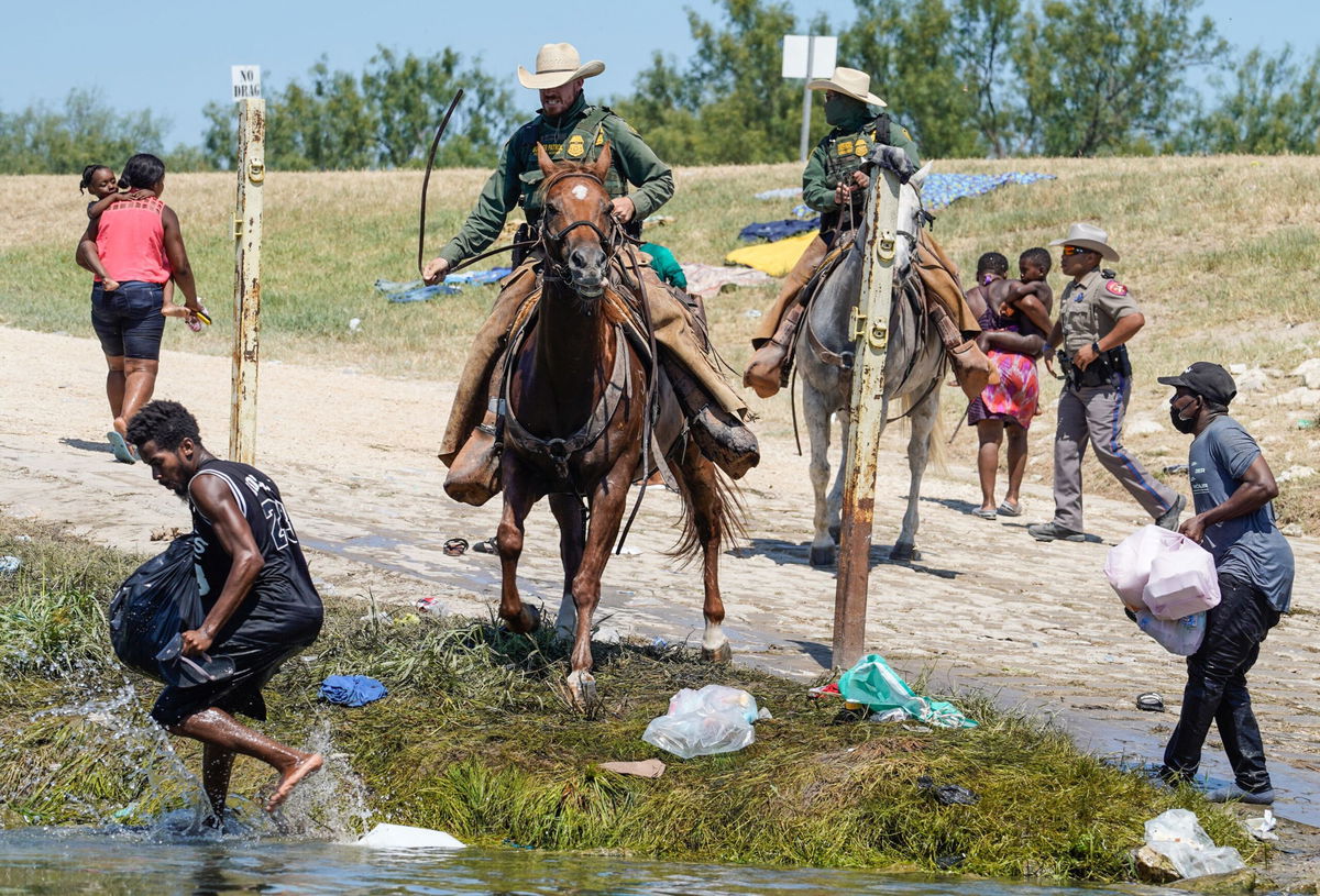 <i>Paul Ratje/AFP/Getty Images</i><br/>United States Border Patrol agents on horseback try to stop Haitian migrants from entering an encampment on the banks of the Rio Grande near the Acuna Del Rio International Bridge in Del Rio