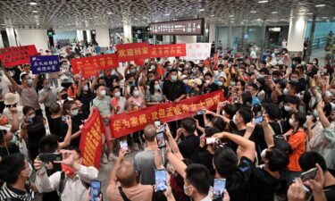 Crowds hold banners and placards reading "welcome home Meng Wanzhou" as they wait for Huawei executive Meng Wanzhou at Shenzhen Bao'an International Airport on September 25.