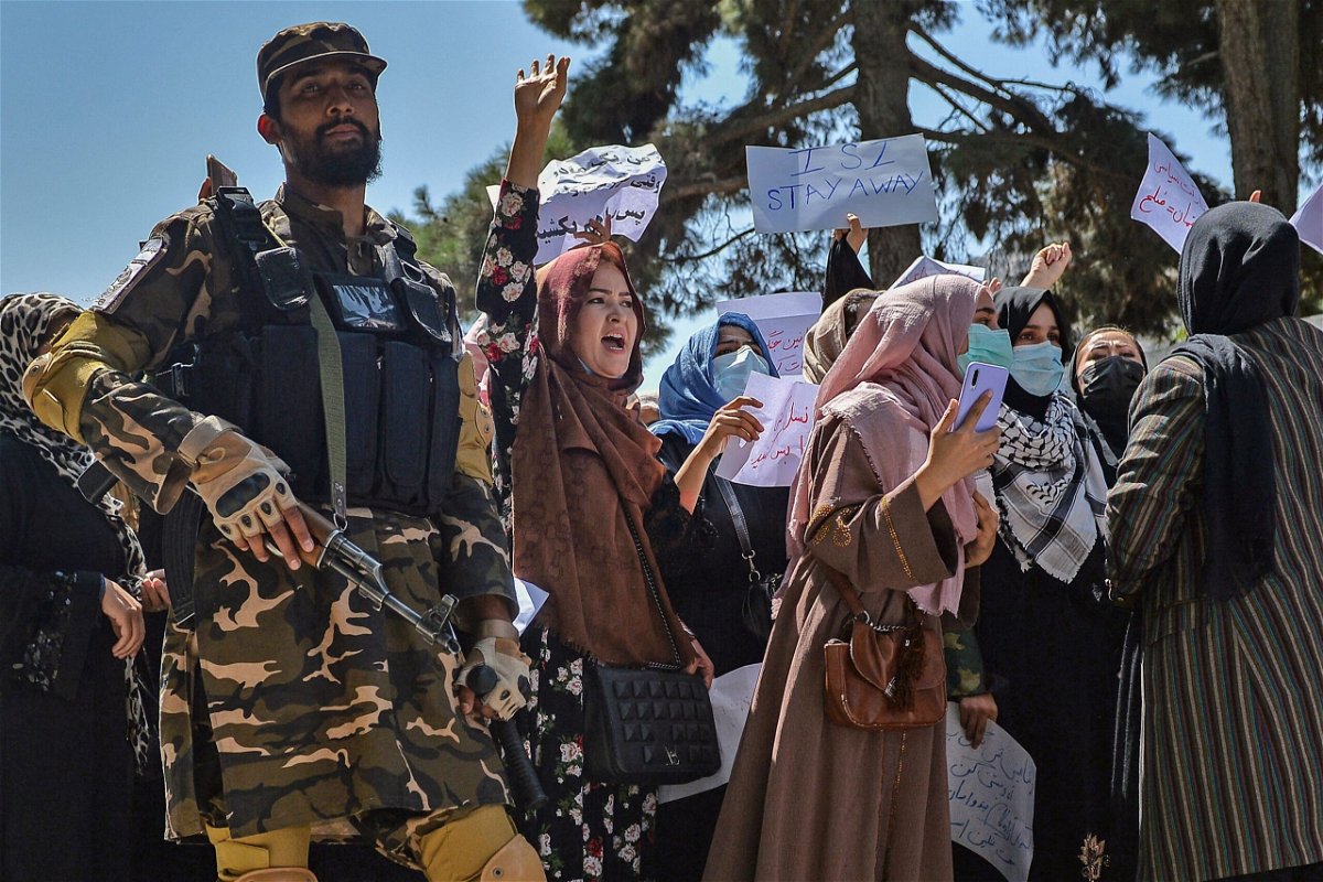 <i>Hoshang Hashimi/AFP/Getty Images</i><br/>A Taliban fighter stands guard as Afghan women shout slogans during a rally near the Pakistan embassy in Kabul on September 7.