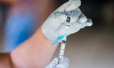 A nurse fills a syringe with a dose of BioNTech