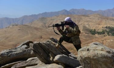 An anti-Taliban fighter takes a position during a patrol on a hilltop in Darband area in Anaba district