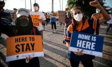 People hold signs during a rally in support of the Supreme Court's ruling in favor of the Deferred Action for Childhood Arrivals (DACA) program