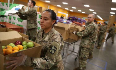 Members of the California National Guard help pack boxes of fruit and other food at the Second Harvest Food Bank of Silicon Valley on March 24