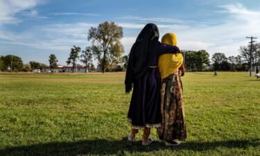 Afghan refugee girls watch a soccer match near where they are staying in the Village at the Ft. McCoy U.S. Army base on September 30 in Ft. McCoy