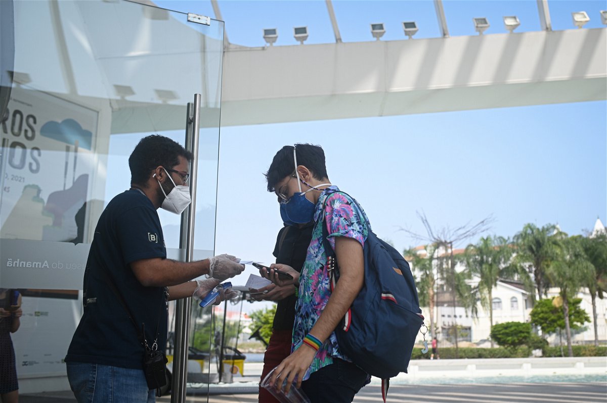 <i>Bloomberg/Bloomberg/Bloomberg via Getty Images</i><br/>Visitors display vaccine verification at the entrance to the Museum of Tomorrow in Rio de Janeiro