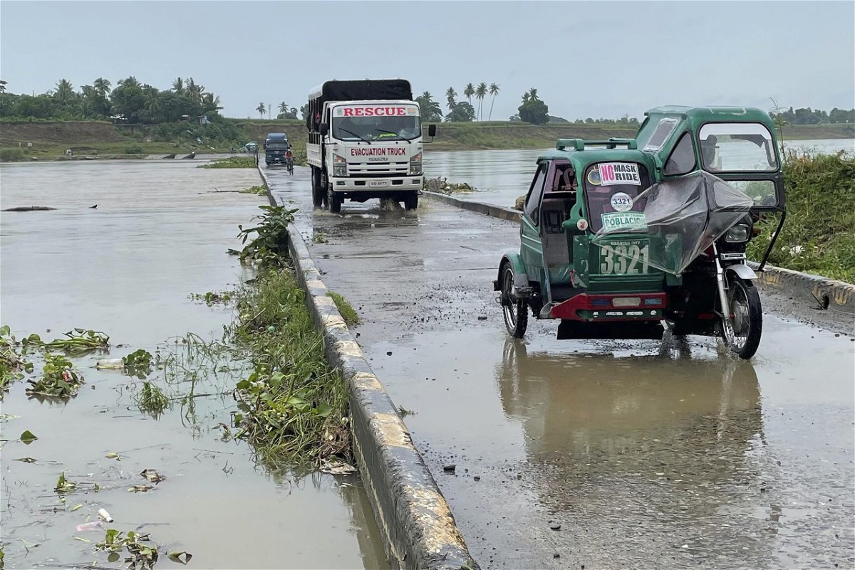 <i>AP</i><br/>Motorists cross a bridge as the river starts to swell due to approaching Super Typhoon Chanthu in Cauayan