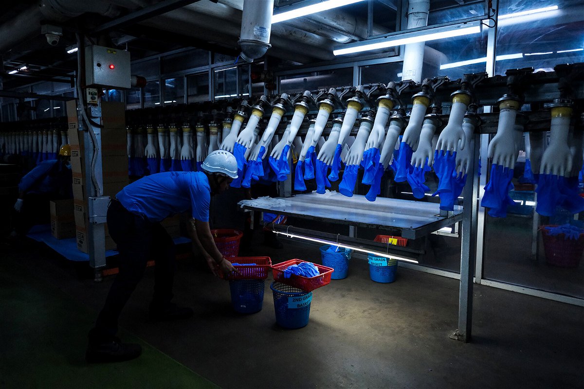 <i>Samsul Said/Bloomberg/Getty Images</i><br/>An employee monitors latex gloves on hand-shaped molds moving along an automated production line at a Top Glove factory in Selangor
