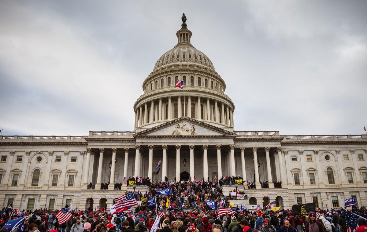 <i>Jon Cherry/Getty Images</i><br/>A large group of rioters stand on the East steps of the Capitol Building after storming its grounds on January 6 in Washington