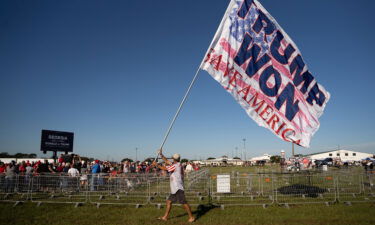 A man carries a flag that reads "TRUMP WON" before a rally featuring former President Donald Trump on September 25 in Perry