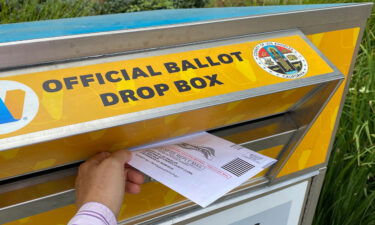 A person drops a ballot for the California gubernatorial recall election in Los Angeles