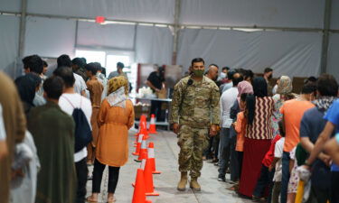 Afghan refugees line up for food in a dining hall at Fort Bliss' Doña Ana Village where they are being housed in Chaparral