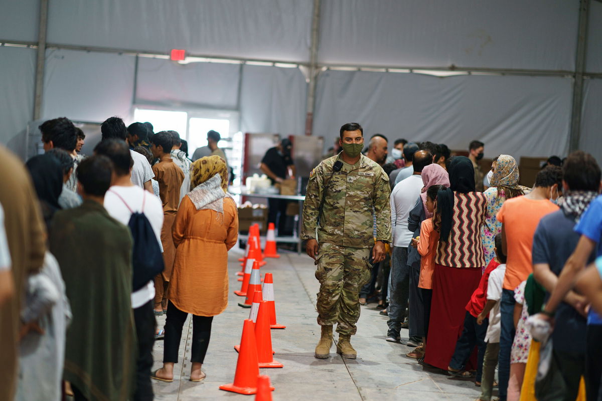 <i>David Goldman/AP</i><br/>Afghan refugees line up for food in a dining hall at Fort Bliss' Doña Ana Village where they are being housed in Chaparral