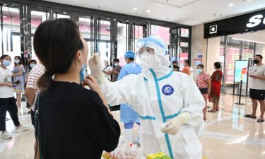 China's strict 21 day quarantine is under question after a new Covid-19 outbreak emerges. A medical worker here collects a throat swab on September 11