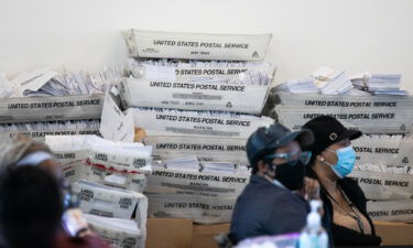 Security envelopes for absentee ballots sit in stacked boxes as Fulton County workers continue to count absentee ballots at State Farm Arena on November 6