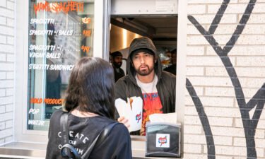 Eminem serves a fan on the opening night of his restaurant Mom's Spaghetti in Detroit.