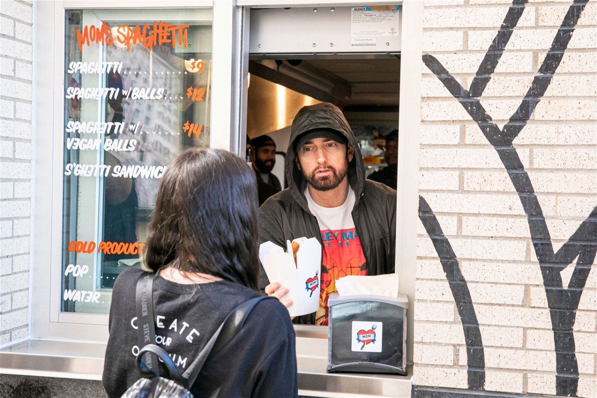 <i>Scott Legato/Getty Images</i><br/>Eminem serves a fan on the opening night of his restaurant Mom's Spaghetti in Detroit.