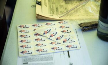 "I voted" stickers and other forms line a table at a ballot drop off location on October 13