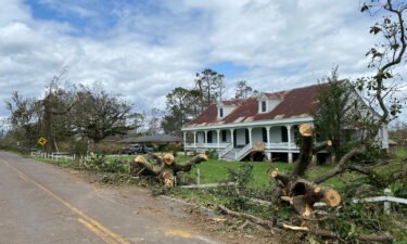 Downed trees are seen around the historic house in LaPlace