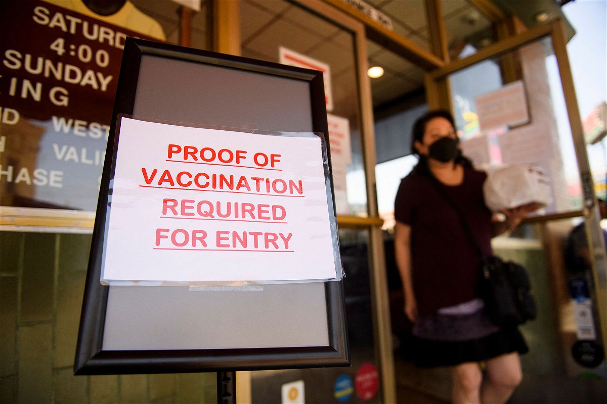 <i>Patrick T. Fallon/AFP/Getty Images</i><br/>A sign stating proof of a Covid-19 vaccination is required is displayed outside of Langer's Deli in Los Angeles on August 7.