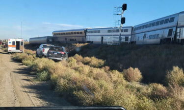 In this photo provided by Kimberly Fossen an ambulance is parked at the scene of an Amtrak train derailment on Saturday