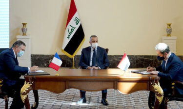 TotalEnergies CEO Patrick Pouyanne (L) with Iraqi Prime Minister Mustafa Al-Kadhimi and oil minister Ihsan Abdul-Jabbar Ismail (R) during a ceremony in the Iraq capital Baghdad on September 5.
