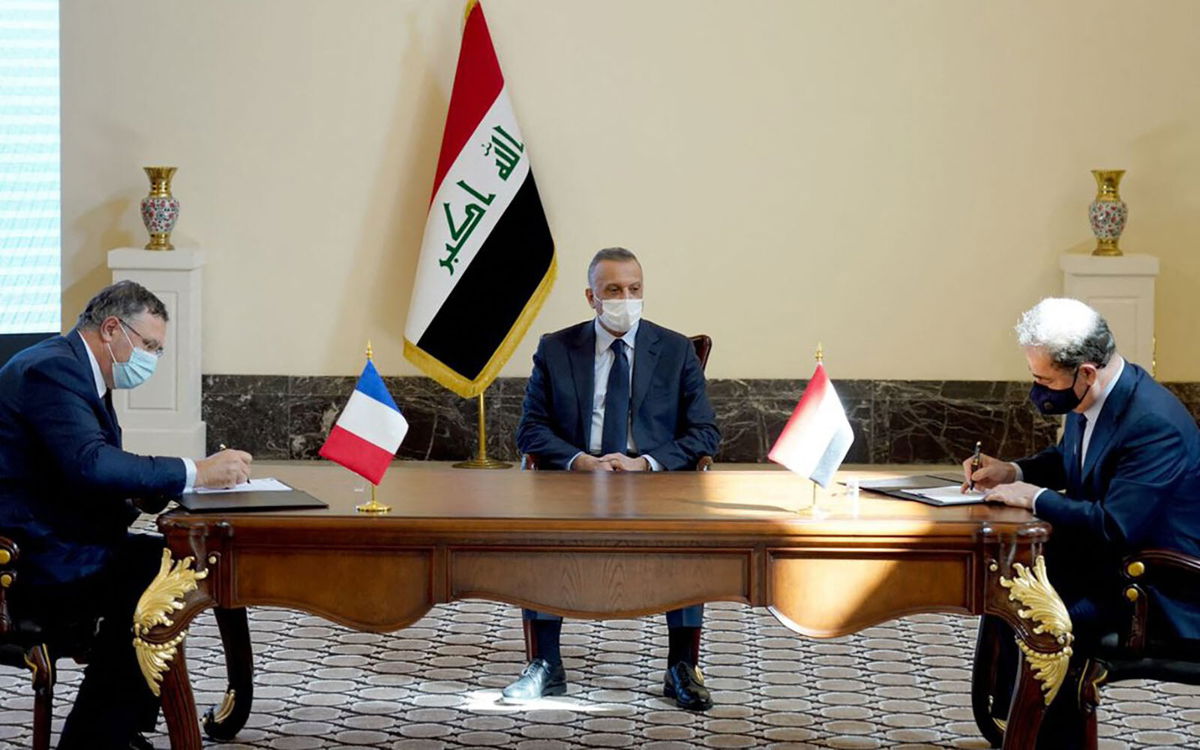 <i>Handout/Iraq's Prime Minister's Media Office/AFP/Getty Images</i><br/>TotalEnergies CEO Patrick Pouyanne (L) with Iraqi Prime Minister Mustafa Al-Kadhimi and oil minister Ihsan Abdul-Jabbar Ismail (R) during a ceremony in the Iraq capital Baghdad on September 5.