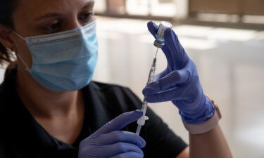 Oakland County Health Department emergency preparedness specialist Jeanette Henson fills syringes with doses of the coronavirus (COVID-19) vaccine on Aug. 24 at the Southfield Pavilion in Southfield