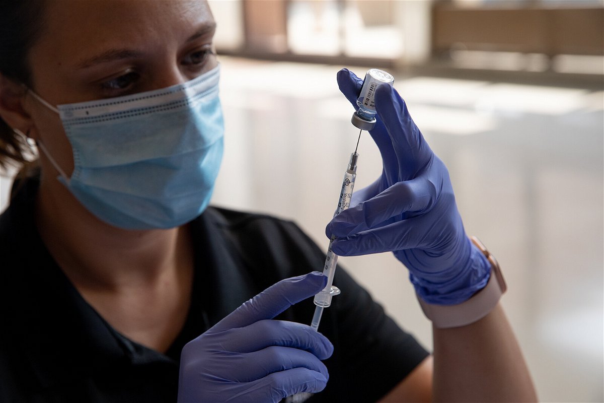 <i>Emily Elconin/Getty Images</i><br/>Oakland County Health Department emergency preparedness specialist Jeanette Henson fills syringes with doses of the coronavirus (COVID-19) vaccine on Aug. 24 at the Southfield Pavilion in Southfield