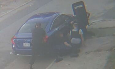 Police officers take cover behind a car during a standoff  on October 7.