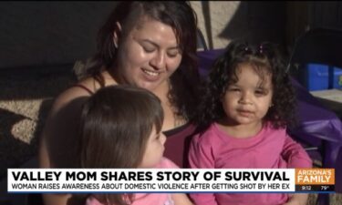 Vanessa Martinez holds her two young children in Mesa