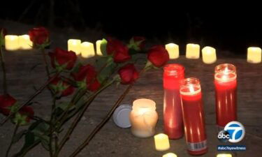 Roses and candles form a memorial for Daina Monroe