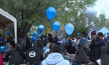 Mourners hold balloons at a gathering in the memory of Isaiah Valerio