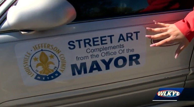 <i>WLKY</i><br/>The abandoned car has a cheeky message posted on the door: Street Art Compliments from the Office of the Mayor.