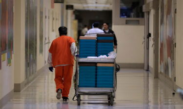 A detainee worker moves a cart of trays containing chicken fajita meals to be served to detainees during a media tour of the ICE detention center in Tacoma