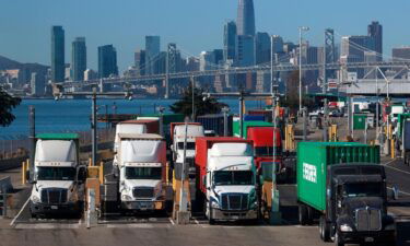 Trucks hauling shipping containers leave the EverPort terminal at the Port of Oakland on October 14