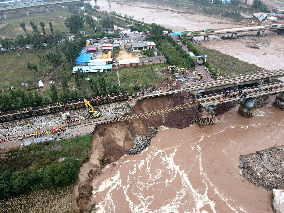 <i>Li Zhaomin/VCG/Getty Images</i><br/>Rescuers repair a bridge damaged by flooding on October 7