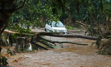 A car is stuck in muddy water after torrential rain in Kerala state on October 16.