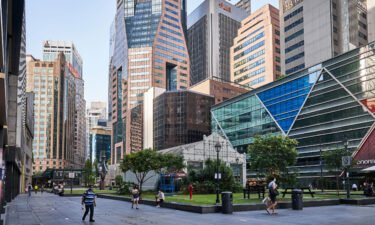 Singapore will extend its Covid-19 restrictions for another month after the city-state reported 18 new deaths from the disease. Pedestrians are seen here passing through a near empty Raffles Place in the central business district of Singapore