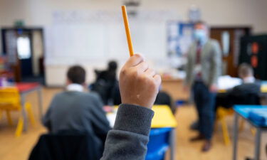 The rollout of Covid-19 vaccinations to schoolchildren in the United Kingdom has opened up a new front in the disinformation war: anti-vax campaigners are now taking their protests to the school gates. A pupil's raised hand is shown here during a lesson at Whitchurch High School on September 14