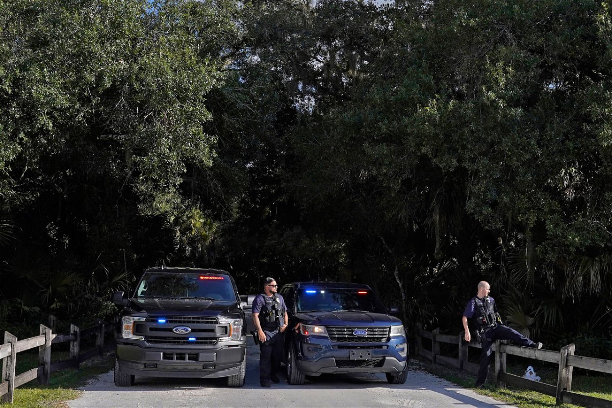 North Port police officers block the entrance to the Myakkahatchee Creek Environmental Park Wednesday, Oct. 20, 2021, in North Port, Fla. Items believed to belong to Brian Laundrie and potential human remains were found in a Florida wilderness park during a search for clues in the slaying of Gabby Petito . (AP Photo/Chris O'Meara)