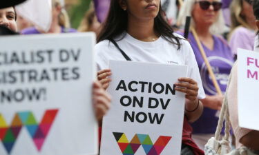 Women hold signs urging action against domestic violence during the 2020 International Women's Day march in Sydney.