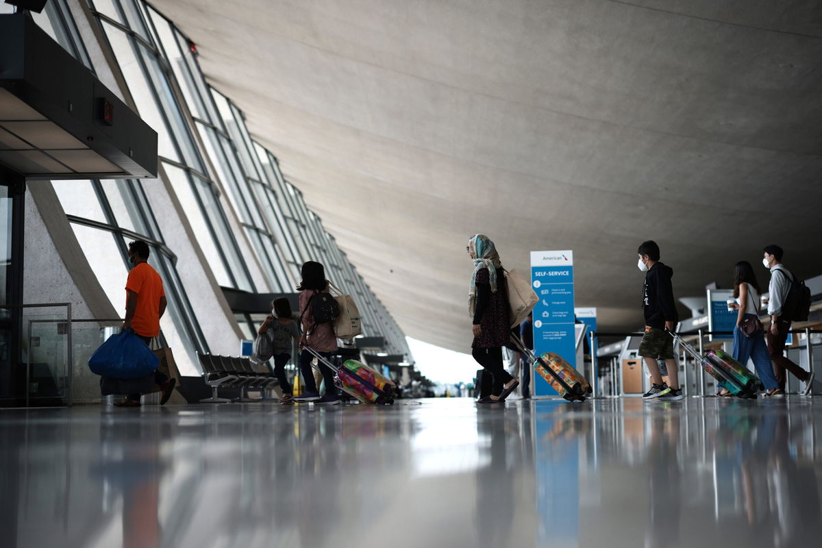 <i>Anna Moneymaker/Getty Images</i><br/>Refugees walk through the departure terminal to a bus at Dulles International Airport after being evacuated from Kabul following the Taliban takeover of Afghanistan on August 31