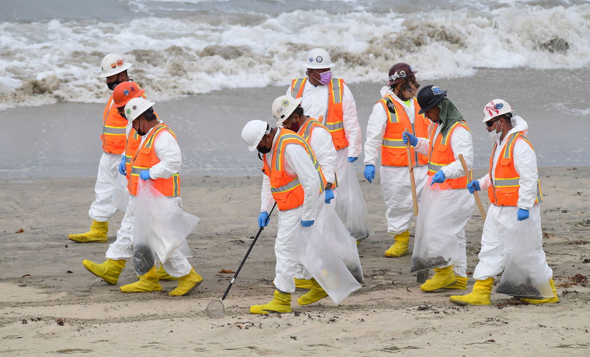<i>Frederic J. Brown/AFP/Getty Images</i><br/>A cleanup crew works on the beach on Thursday
