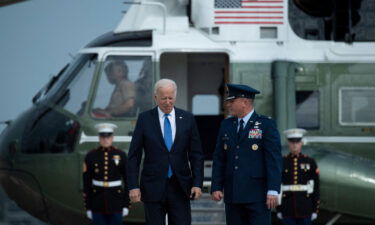 US President Joe Biden is greeted by Col. Matthew Jones (R)