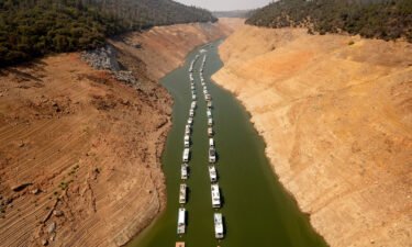 Houseboats sit in a narrow section of water in a depleted Lake Oroville in Oroville