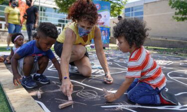 Children from a childcare center complete a mural celebrating the launch of the Child Tax Credit on July 14