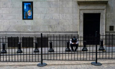 A stock broker takes a break outside the New York Stock Exchange